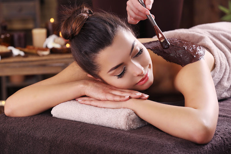 Beautiful young girl having cosmetic mask in spa salon